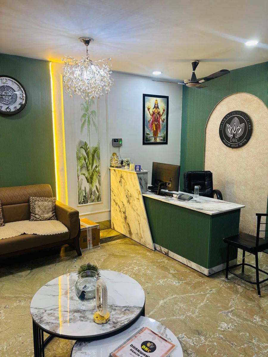 Reception at Dhanwantari Healthcare with green fluted walls, Lord Dhanvantari's picture and the DHC logo